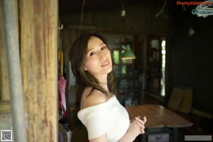 A naked woman standing in front of a wooden door.