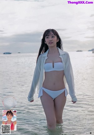 A woman in a red bikini laying on the beach.