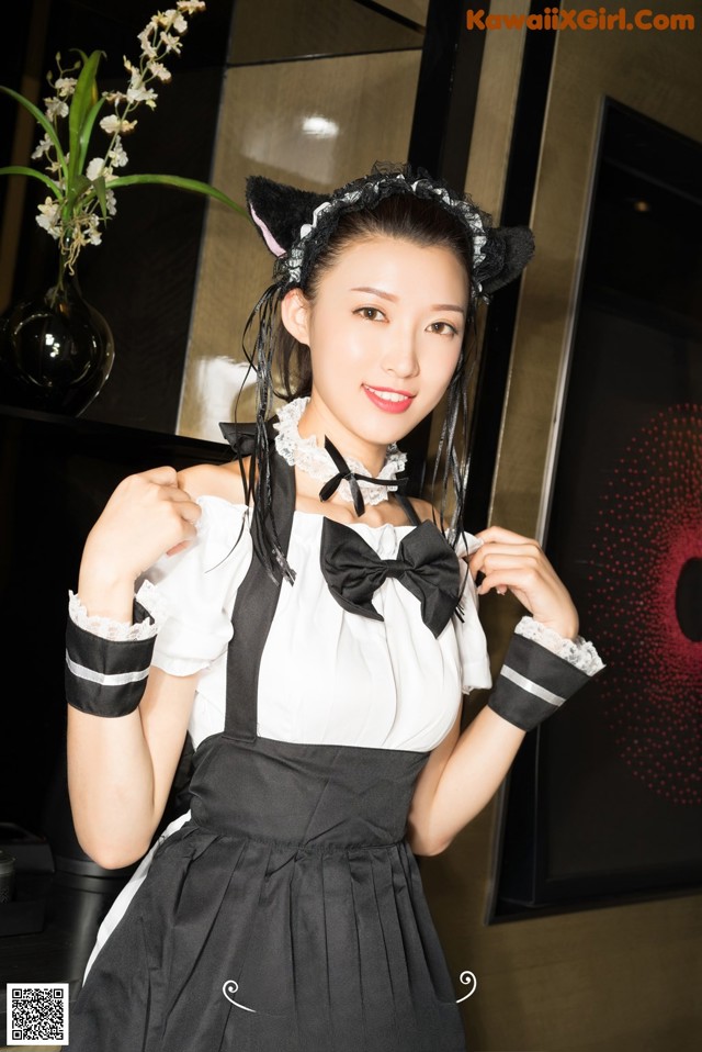 A woman dressed as a maid posing for a picture.