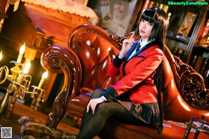 A woman sitting on top of a brown leather chair.