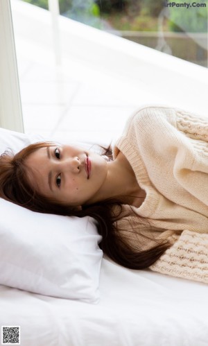 A woman in a blue bra laying on a bed.