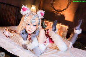 A woman in a cat costume sitting on a wooden floor.