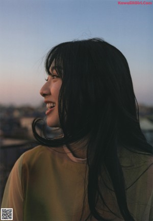 A woman with long black hair is posing for a picture.