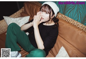 A woman in a bathing suit laying in a bathtub surrounded by balloons.