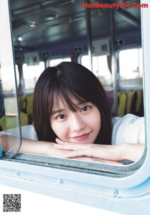 A woman in a white dress holding a piece of food.