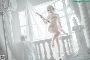 A woman in a white lingerie sitting on the floor.