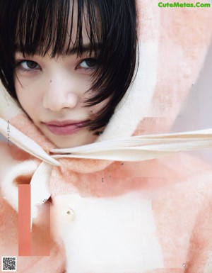 A woman laying on the ground wearing a brown teddy bear coat.