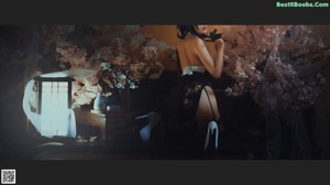 A woman sitting on the floor next to a bunch of flowers.