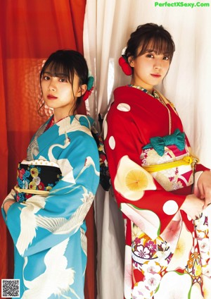 Two young women standing next to each other on a balcony.