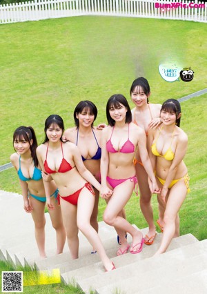 A group of three young women in bikinis posing for a picture.