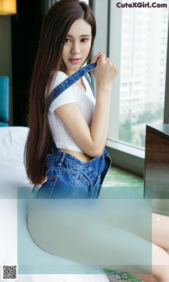 A woman sitting on top of a bed next to a window.