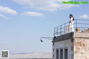 A woman in a black dress is sitting on a set of stairs.