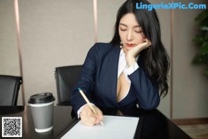 A woman sitting on a chair in an office.