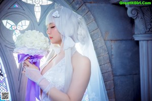 A woman in a wedding dress sitting in front of a window.