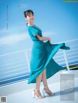 A woman in a black dress sitting on a wooden floor.