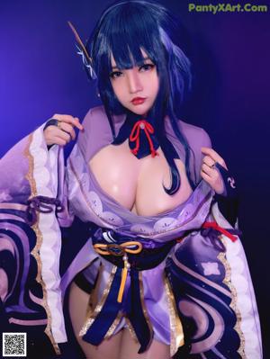 A woman in a purple and blue outfit posing for a picture.