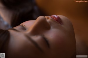 A woman sitting on a bed looking out a window.