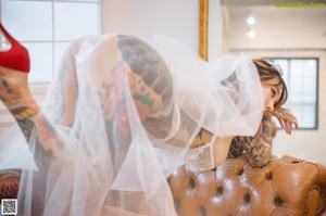 A woman with tattoos sitting in front of a mirror.
