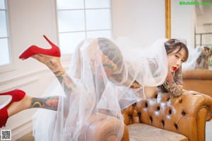 A woman in a wedding dress standing in front of a window.