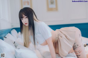 A woman laying on a bed with writing on her butt.