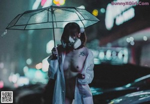 A woman in a white raincoat holding an umbrella in the rain.