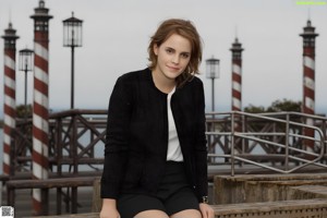 A woman in a white top and plaid skirt posing for a picture.